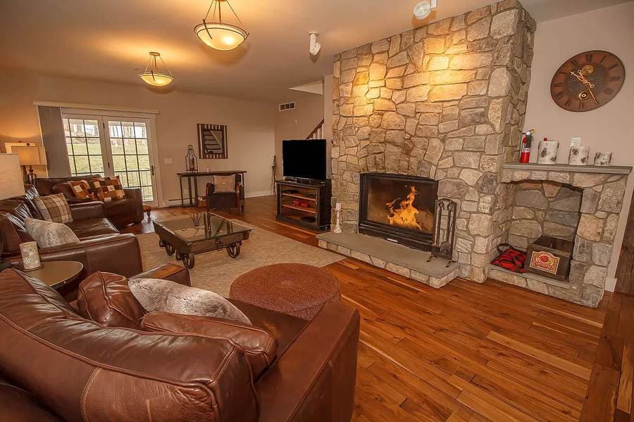 The same living room finished with hardwood floors and a working stone fireplace