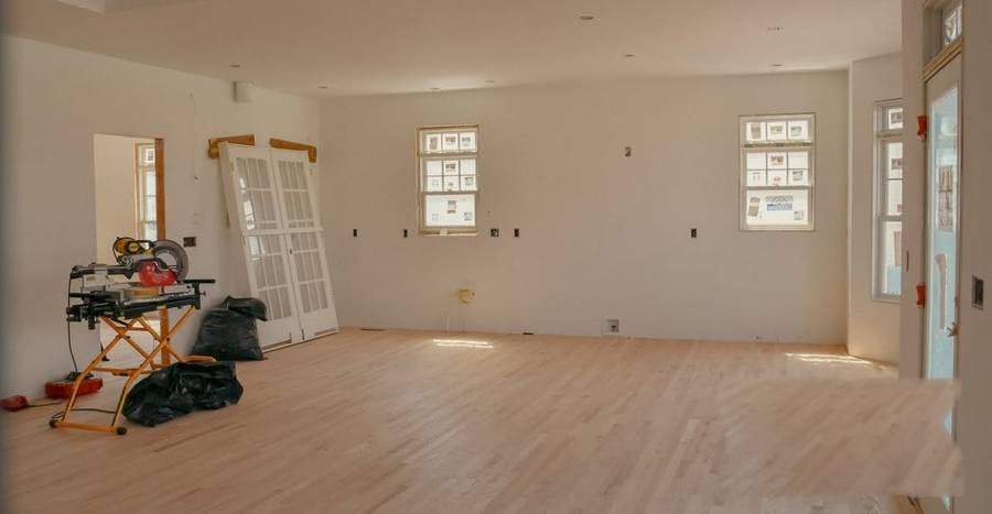 Rebuilt room with fresh hardwood floors ready for final trim and paint